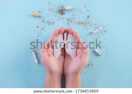 Hands protect lungs from cigarette on light blue background. Stop smoking. World No Tobacco Day concept. Copy space for advertisers.