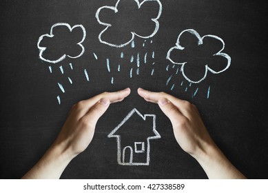 hands protects a house from the elements - rain or storm