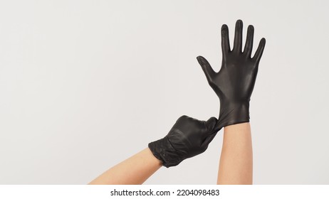 Hands Is Pulling Black Latex Gloves On White Background.