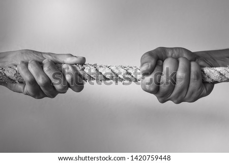 Hands pulling rope playing tug of war, people competitive, dispute, contest concept. 