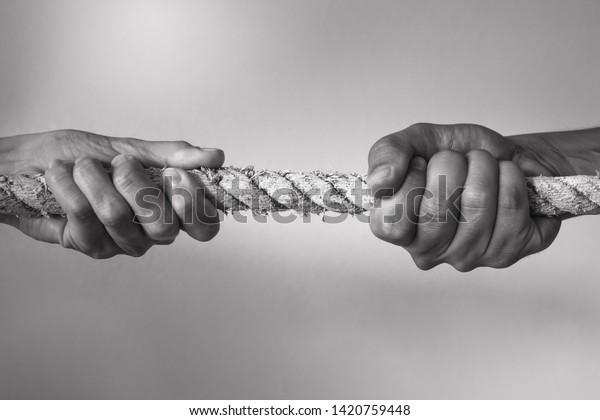 Hands pulling rope playing tug of war,\
people competitive, dispute, contest concept.\
