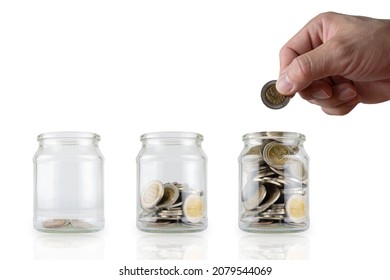 Hands are putting in more coins. Glass bottles with growing coins are like a diagram of savings ideas. White isolated background