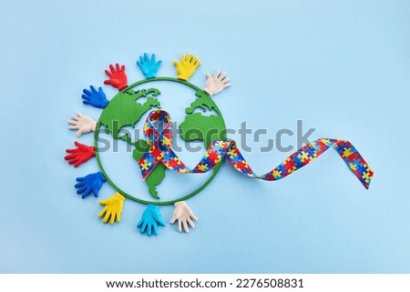 Hands and puzzle ribbon for World Autism Awareness Day.