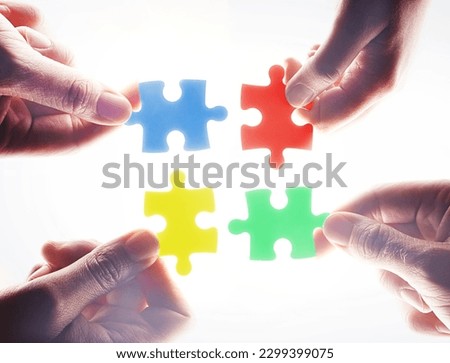 Hands, puzzle and teamwork in group, problem solving or together for support, glow or color by white background. Team building, jigsaw or strategy for innovation, synergy or solution in collaboration