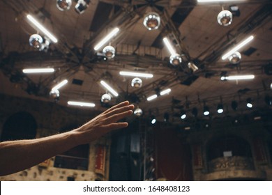 Hands Raised In The Crowd. A Group Of People Stretches Out Their Hands. Bright Lighting. Personal Growth Training. Warm-up For The Audience - All Raised Their Hands Up And Reach Up