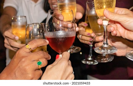 Hands Raising Champagne And Wine Glasses At Night, Toast