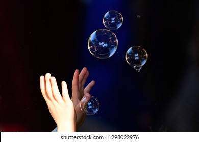 Hands reaching for intangible bubbles
