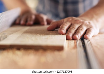 Hands Of A Real Woodworker Sawing A Piece Of Wood With A Table Saw In Woodworking Studio