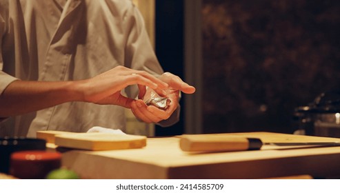 Hands, recipe and chef cooking sushi in restaurant for traditional Japanese cuisine or dish closeup. Kitchen, ingredients for seafood preparation and person working with gourmet food or meal on table - Powered by Shutterstock