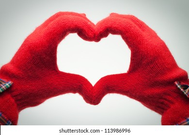 Hands In Red Gloves Show Heart Shaped Sign Over Grey