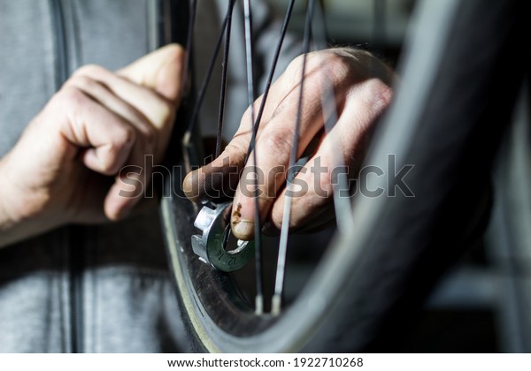 hands repairing a wheel\
of an old bike