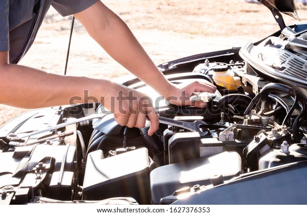 The hands of the repairman are checking the\
order of the engine using modern\
tools.
