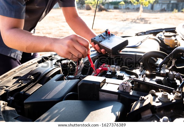 The hands of the repairman are checking the\
order of the engine using modern\
tools.