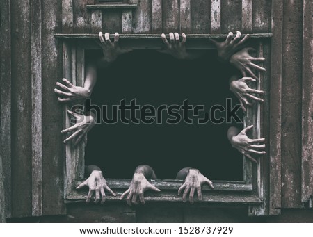 Hands rising out from the old window ancient house, Halloween concept.