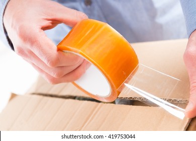 Hands With Roll Of Transparent Packaging, Adhesive Tape.