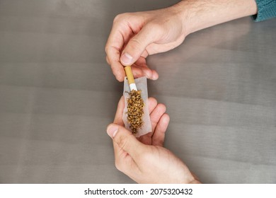 Hands Rolling A Laugh-making Cigarette With Thin Rice Paper