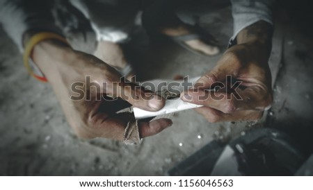 Hands are rolling paper cigarette.
