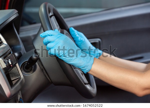 Hands in rubber protective glove\
driving vihicle for protection from virus corona\
disease