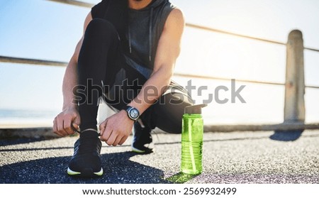 Hands, runner and shoelaces for training at beach, boardwalk or outdoor in summer by water bottle. Person, exercise and ready for challenge, start or workout with sneakers on promenade in Costa Rica
