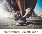 Hands, runner or tie shoes in street for cardio training, running exercise and fitness workout in footwear. City, man and African athlete on ground ready to start jog, race or marathon in closeup