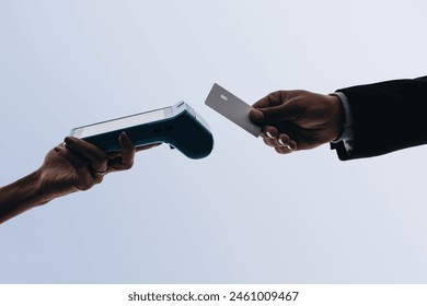 Hands scan a bank card for contactless payment at a checkout. The card reader enables convenient, cashless transactions. With NFC technology, customers can tap to pay, making the process seamless - Powered by Shutterstock