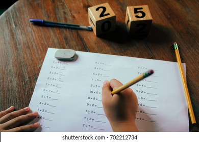 Hands Of A School Kid Doing His 1st Grade Math Homework.