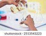 Hands, scientist and mixing of chemicals at lab for chemistry investigation, science study and medical analysis. Person, beaker and liquid for vaccine experiment, engineering solution and innovation