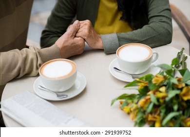 Hands Of Senior Couple Having Romantic Date In A Cafe