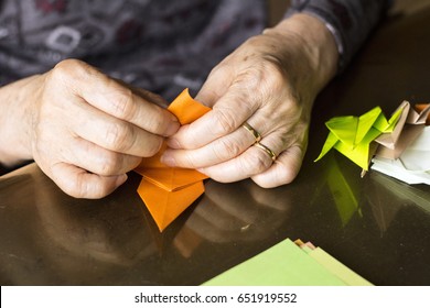 Hands Of Senior Lady Folding Origami Paper