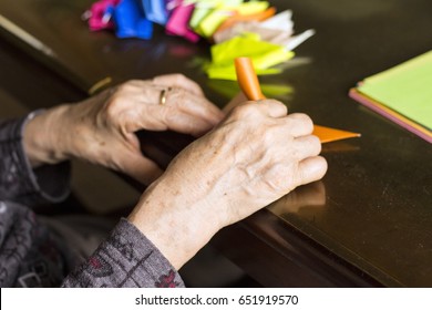 Hands Of Senior Lady Folding Origami Paper