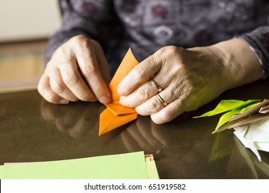 Hands Of Senior Lady Folding Origami Paper