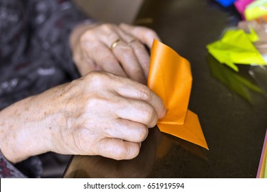 Hands Of Senior Lady Folding Origami Paper