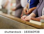 Hands of a senior woman while praying in a church