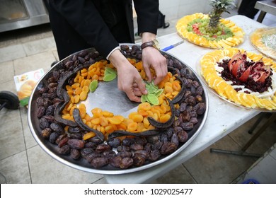 Hands Set Up Dried And Fresh Fruit On A Fruit Platter For A Holiday Event