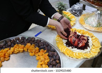 Hands Set Up Dried And Fresh Fruit On A Fruit Platter For A Holiday Event