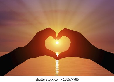 Hands In Shape Of Heart Around Sunset 