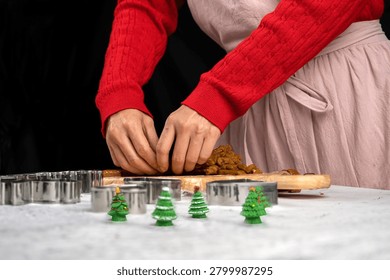 Hands shaping and separating gingerbread cookie dough during Christmas baking preparation. Festive homemade treats, holiday traditions, seasonal dessert making and family kitchen activities