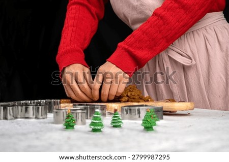 Hands shaping and separating gingerbread cookie dough during Christmas baking preparation. Festive homemade treats, holiday traditions, seasonal dessert making and family kitchen activities