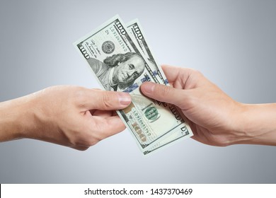 Hands sharing dollars on gray background