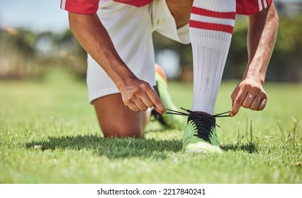 Hands, shoes and soccer player at a soccer field, tie lace and prepare for training, sports and fitness game. Football, hand and football player getting ready for workout, exercise and sport practice - Powered by Shutterstock