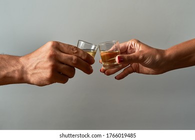 Hands with shot glasses toasting. Concept of alcoholism and addiction.