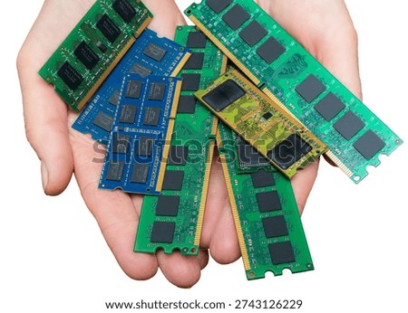 Hands show a mix of memory modules like DRAM and DDR. The current shortage of these components affects many industries.