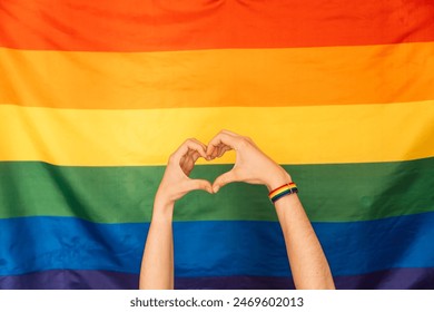 Hands showing heart and love against LGBT flag.