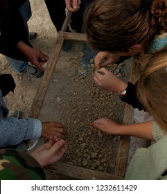 Hands Sifting Stones At Archaeological Dig