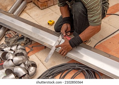 Hands Of Skilled Workers Measure And Mark On Stainless Steel Rain Gutters With The Iron Ingot For Cuts.