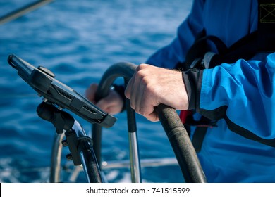 Hands of the skipper at the helm control of sailing boat - Powered by Shutterstock