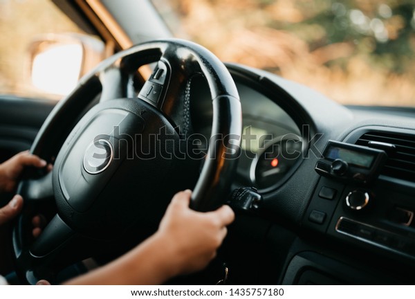 hands of a small child driving a car. driving\
instruction in childhood.