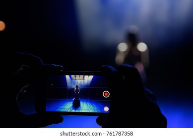 Hands with a smartphone records live music festival and taking photo of concert stage live concert luxury party in facebook live.
