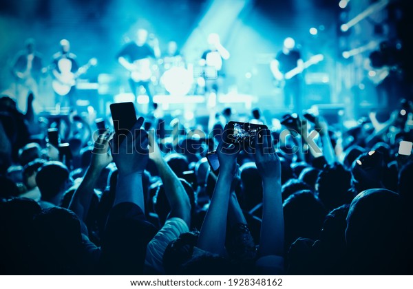 A lot of hands with the\
smartphone turned on to record or take pictures during the live\
concert