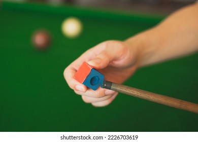 Hand's of snooker is chalking cue. Concept of playing activity, entertainment leisure, billiards, snooker or pool ball. Blue chalk. Hobbies and lifestyles.